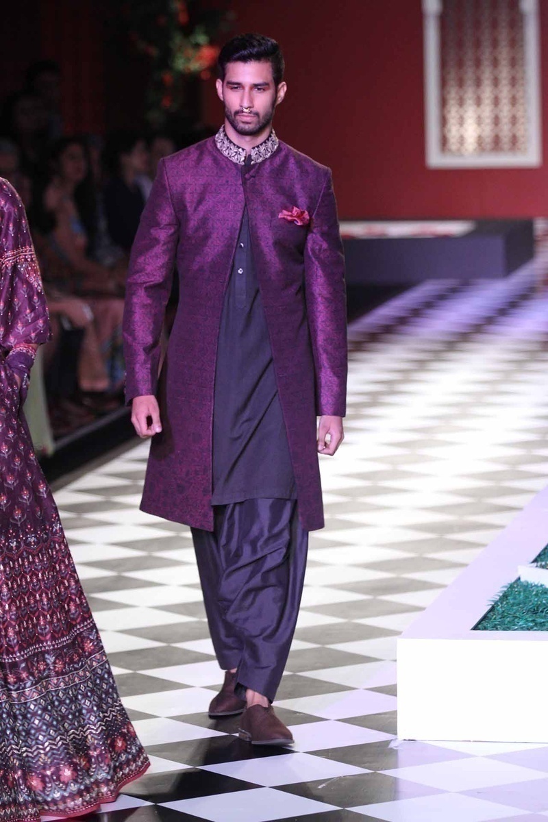 Aubergine purple and black jacket styled lehengas and dhotis with a mandrin collared jackets. Additional details of tassles and belts only upped the style quotient on these stunning outfits!